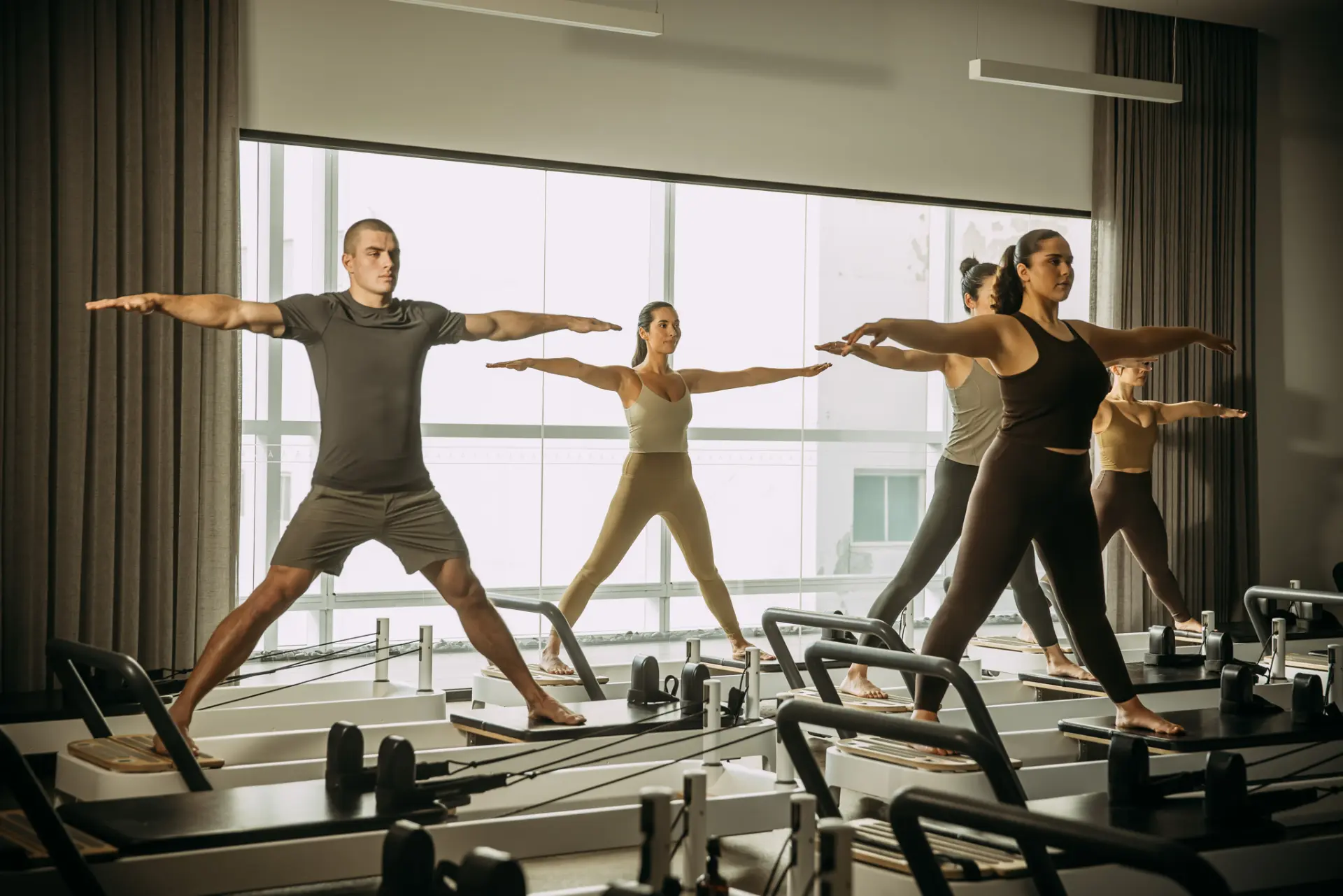 People with arms and legs wide a part on reformer bed