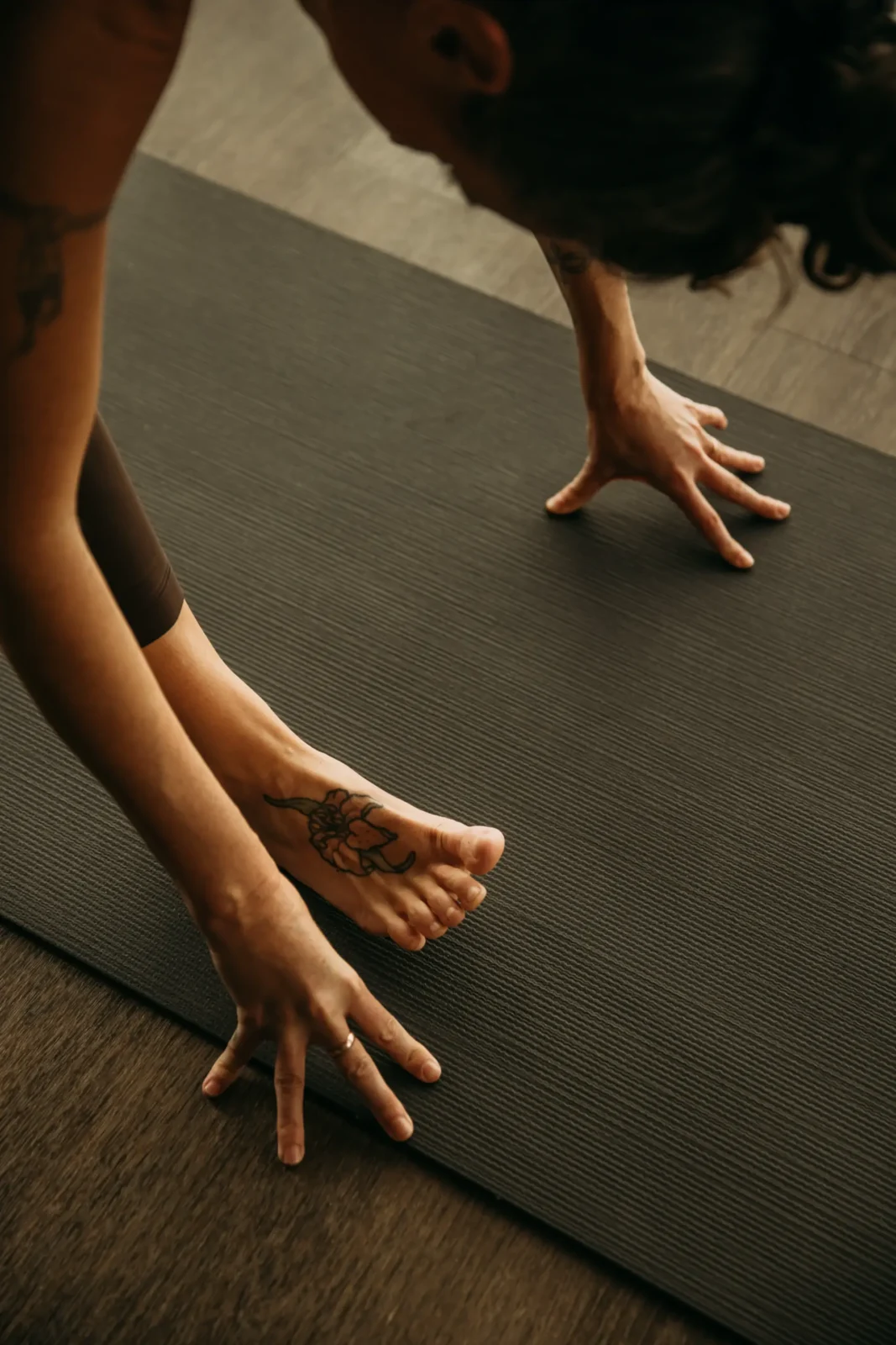 Person with hands and feet on yoga mat