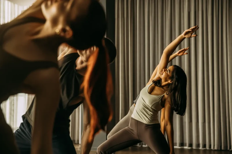 Person holding position with right arm raised over to the left