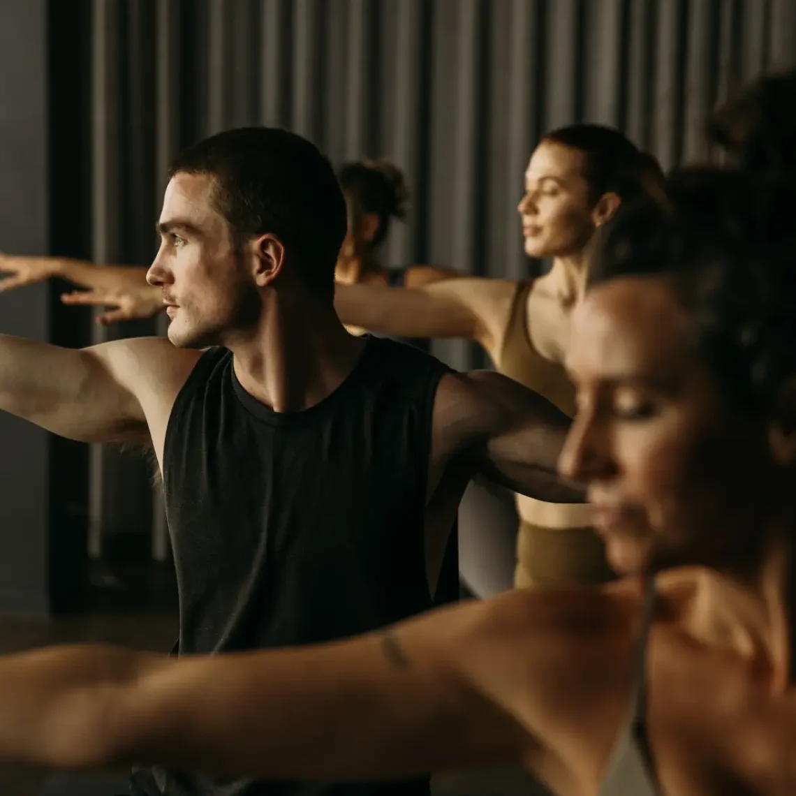 People in yoga pose with arms a part