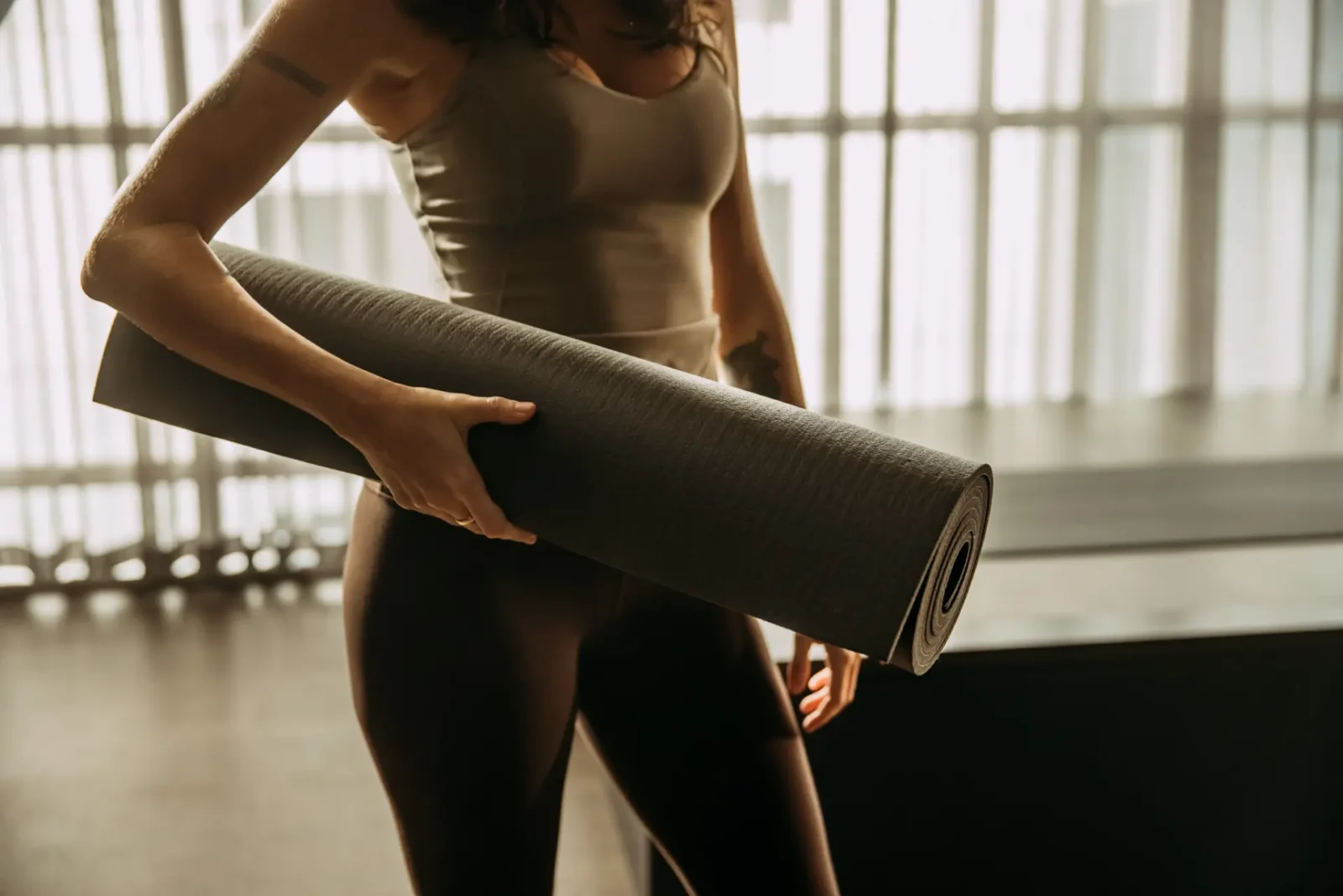 Person holding yoga mat