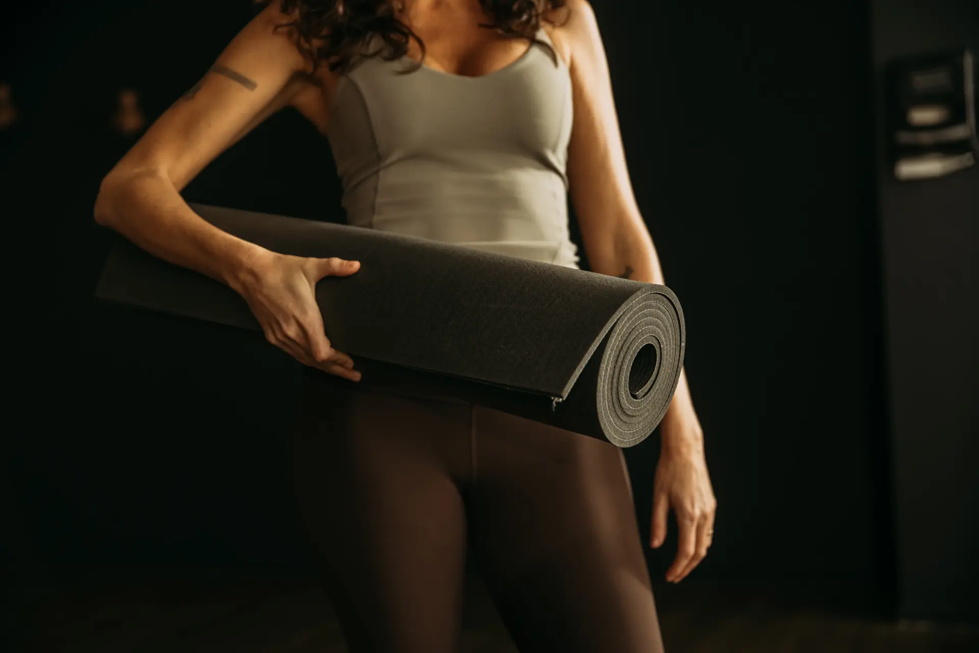 Person holding yoga mat