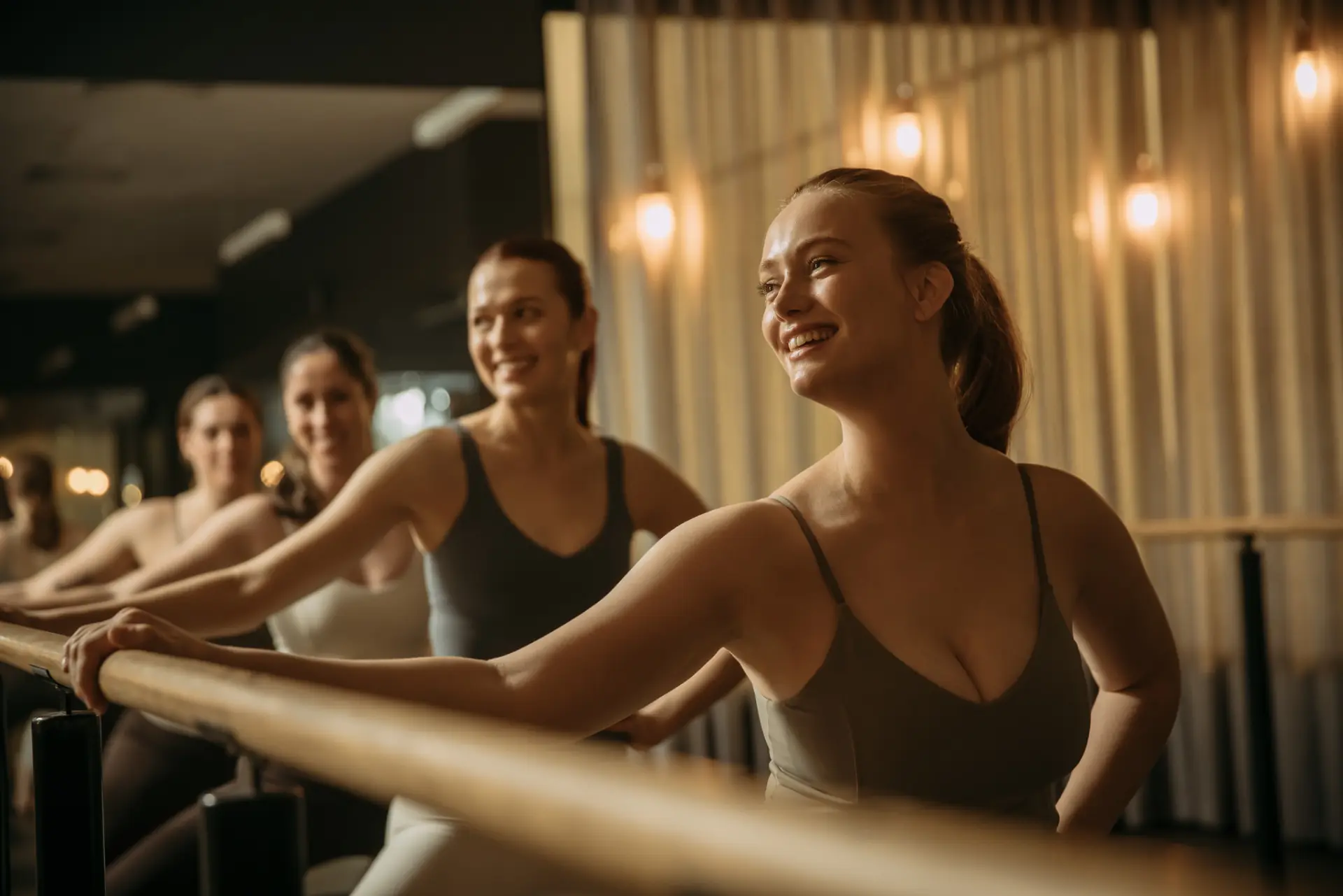 Row of people with right hand on bar and left hand on hip