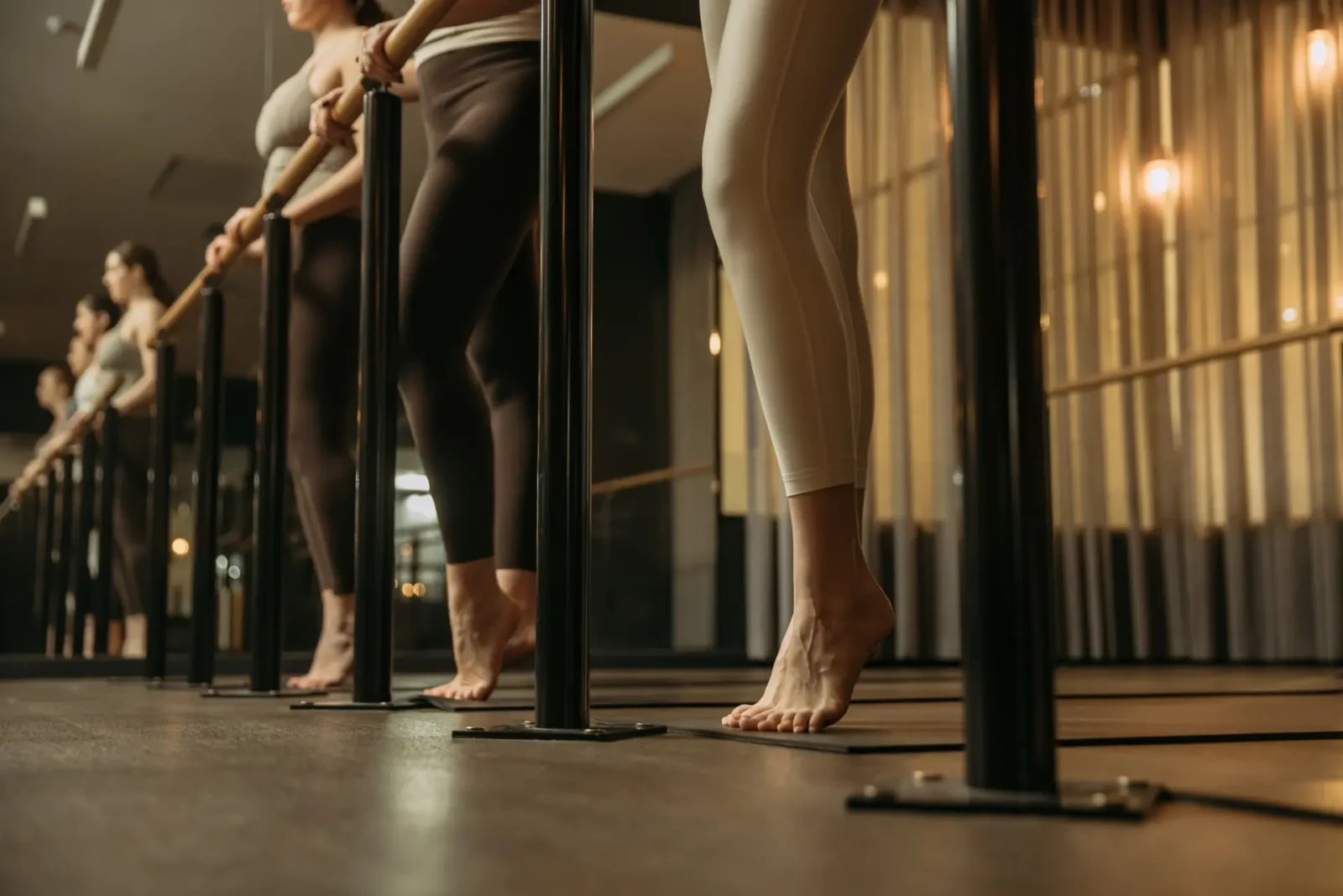Row of people standing on toes with hands on bar