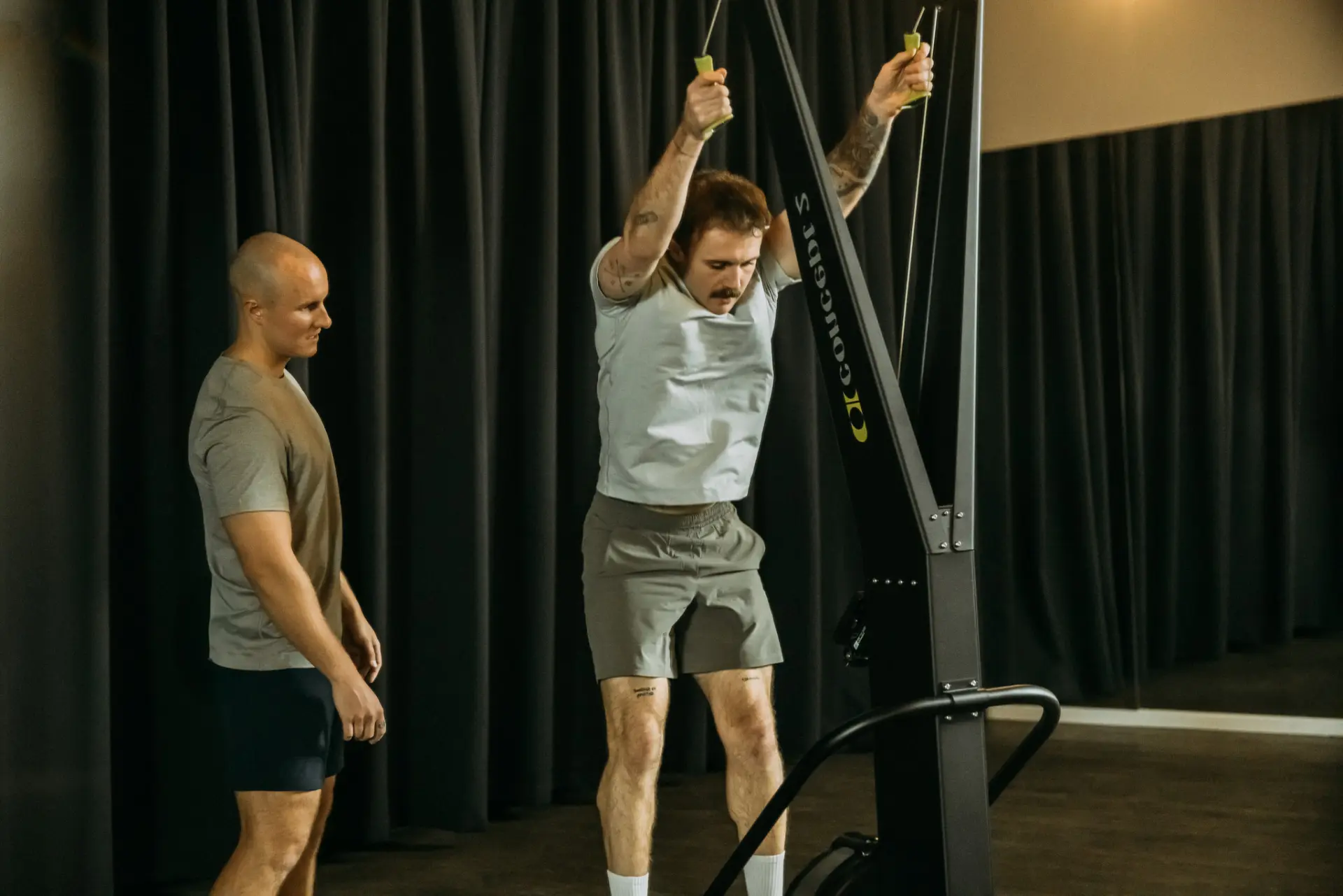 Person using pulling down handles of fitness machine