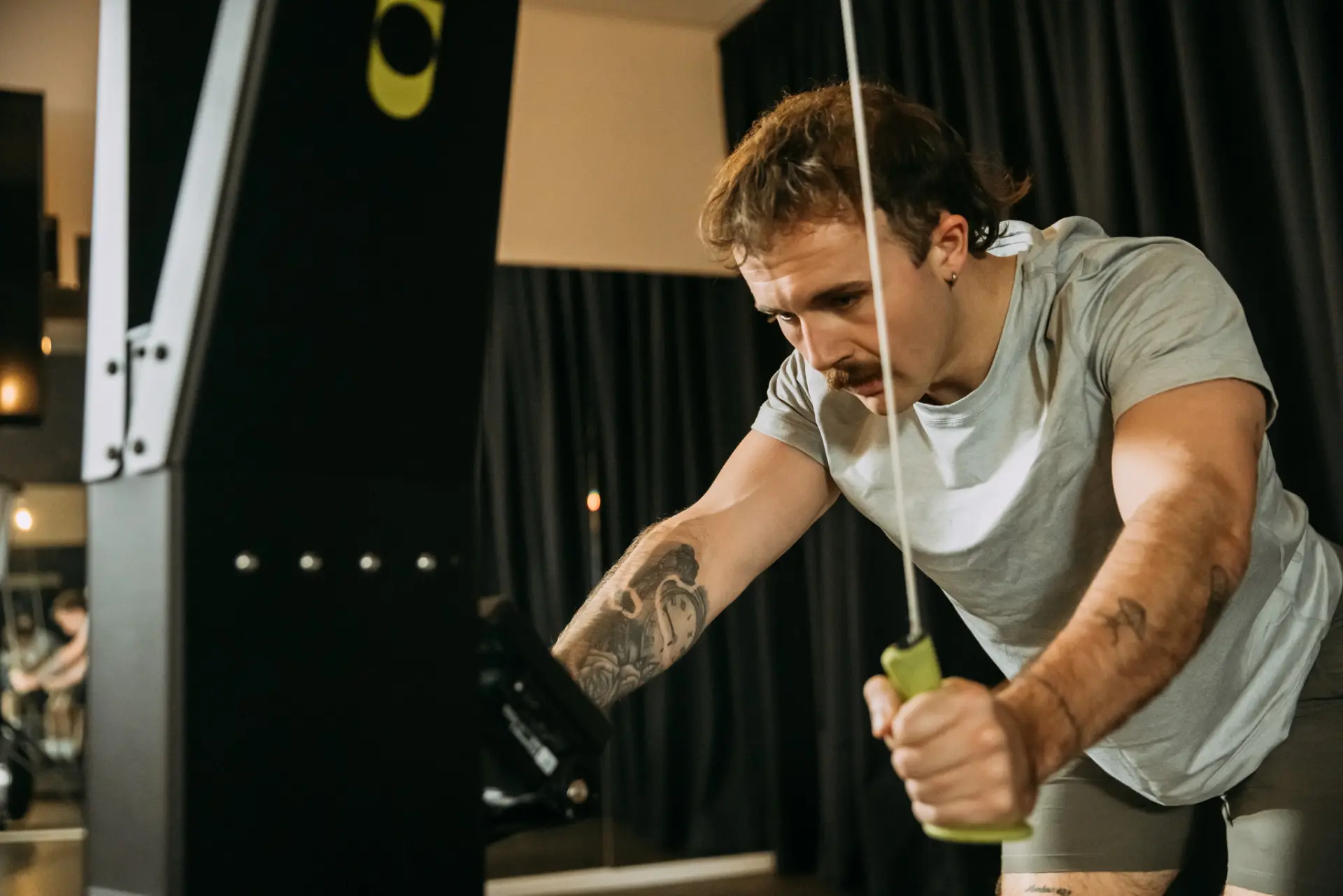 Person using pulling down handles of fitness machine